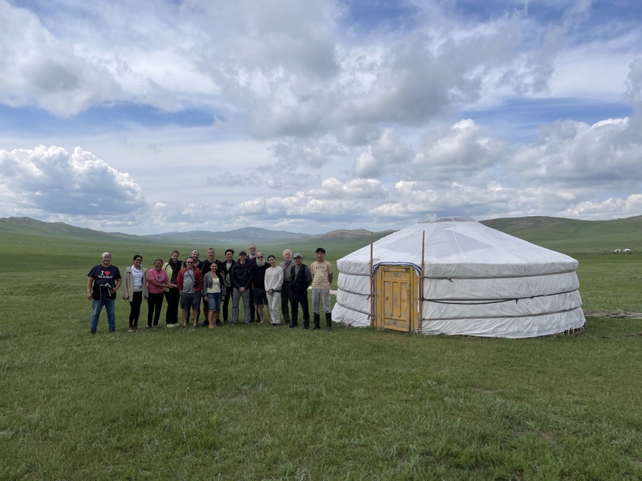 Tuul Travel founder Maamkhuu Otgontuul with travelers in front of a white ger on the steppe